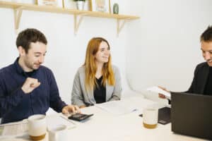 Professional business women engaging in a meeting with colleagues, exchanging ideas for a project. Diverse business people working together in an office.